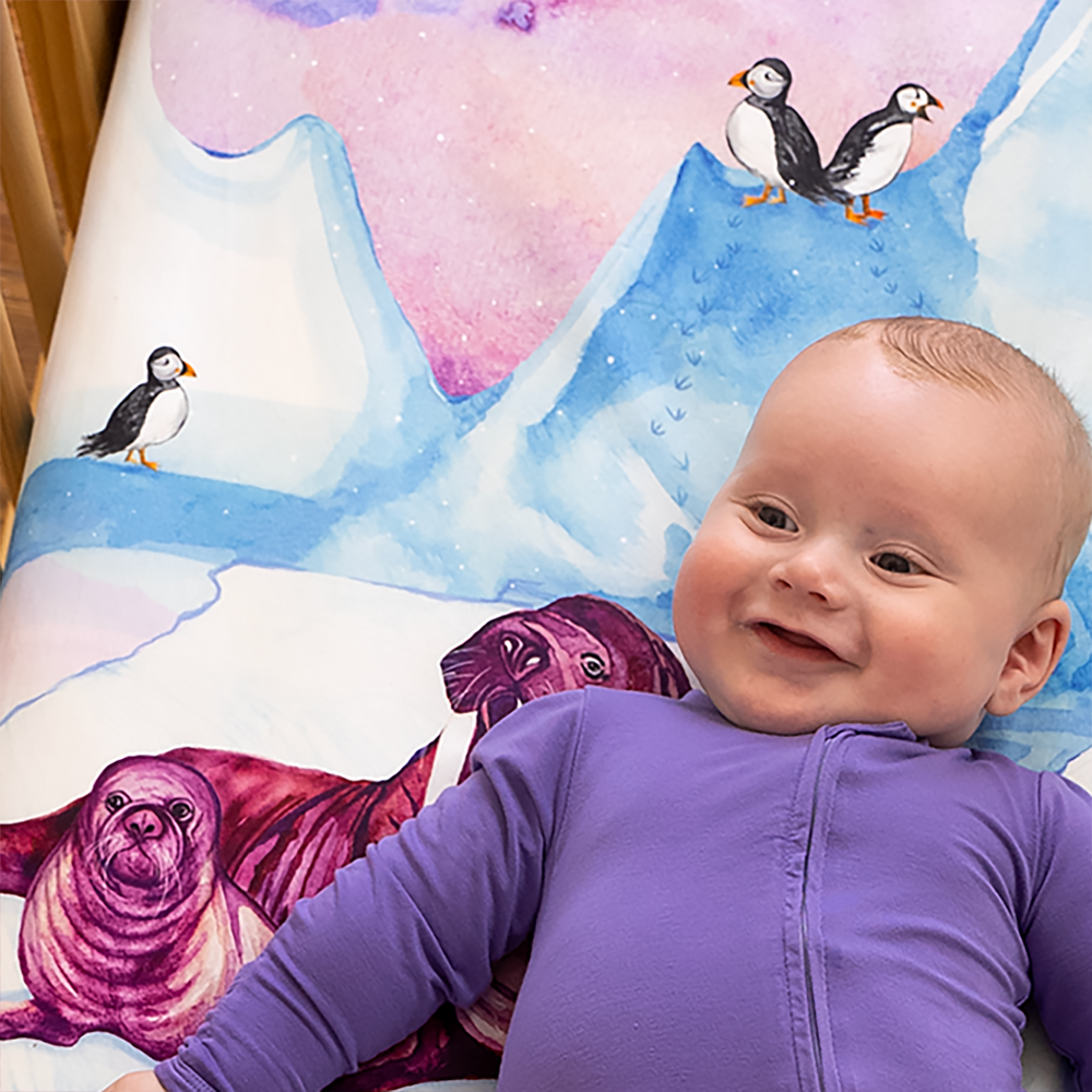 baby smiling on arctic themed crib sheet